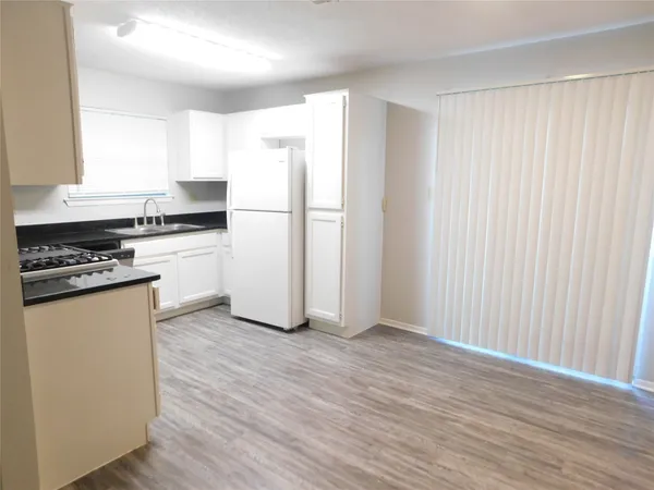 a kitchen with granite countertop a refrigerator sink and stove