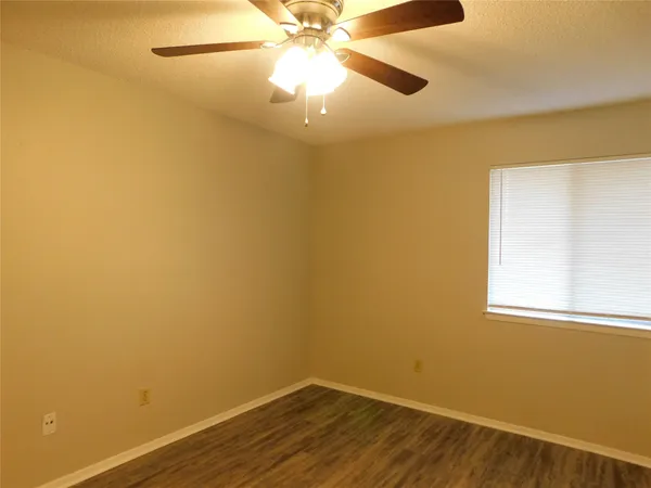 an empty room with a window and a ceiling fan
