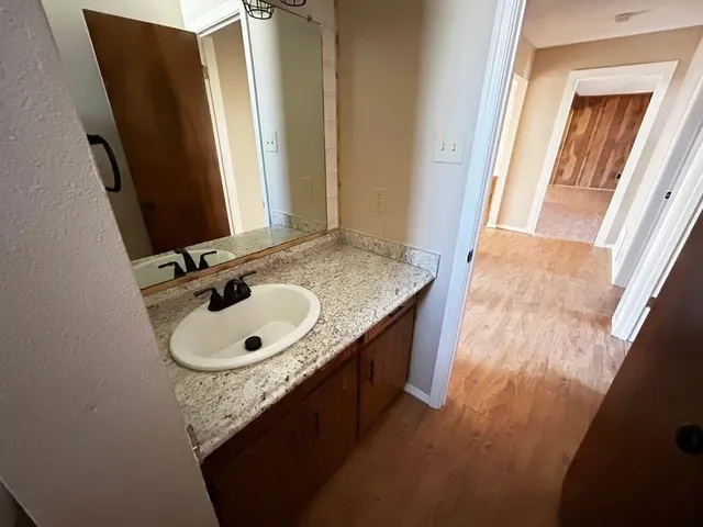 a bathroom with a granite countertop sink and a mirror