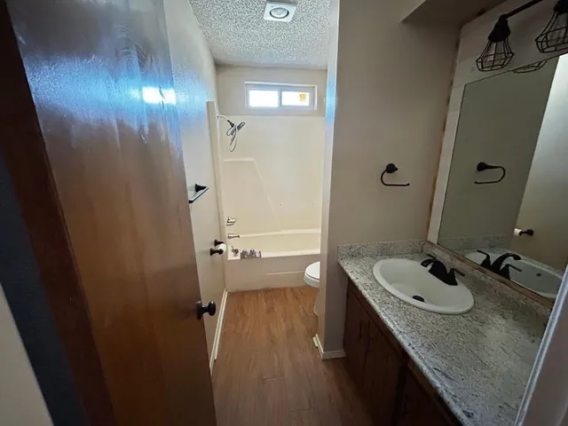 a bathroom with a granite countertop sink a mirror and a shower
