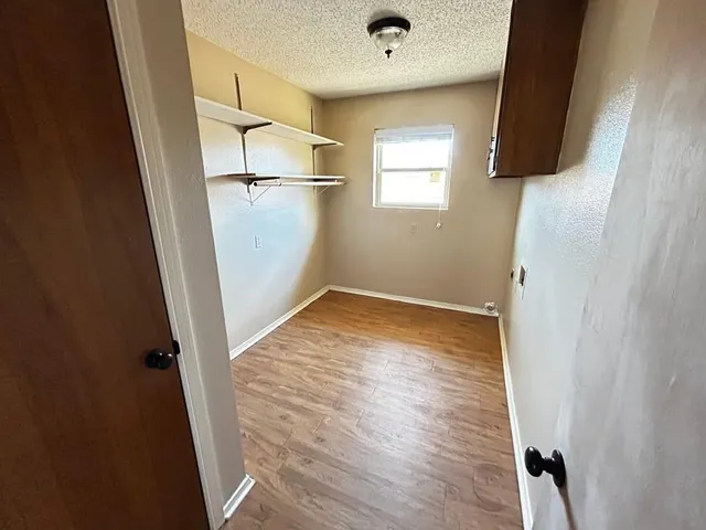 a view of a room with wooden floor and white walls