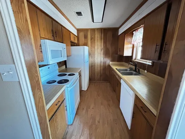 a kitchen with a refrigerator a stove top oven a sink and dishwasher