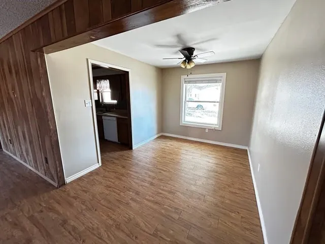 an empty room with wooden floor and window