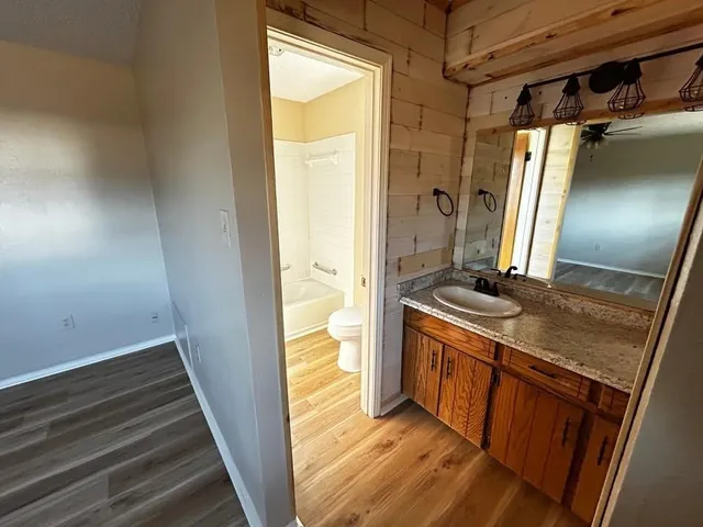 a bathroom with a granite countertop sink a mirror and a shower
