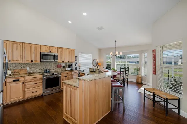 a kitchen with stainless steel appliances kitchen island granite countertop a stove a sink and a refrigerator