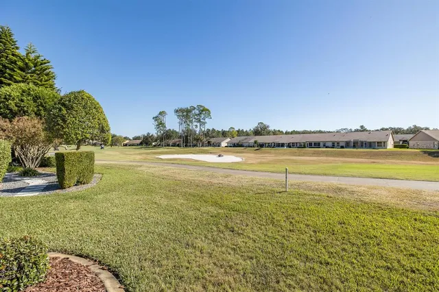 an aerial view of residential houses with outdoor space and trees