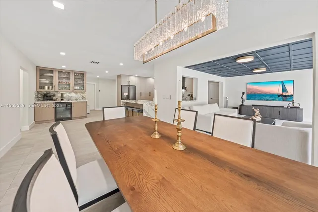 a room with kitchen island stainless steel appliances living room and chandelier