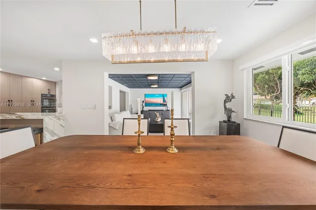 a large white kitchen with stainless steel appliances granite countertop a stove and a sink