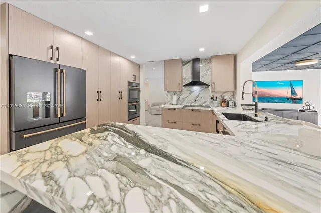 a large kitchen with a large counter top stainless steel appliances and cabinets