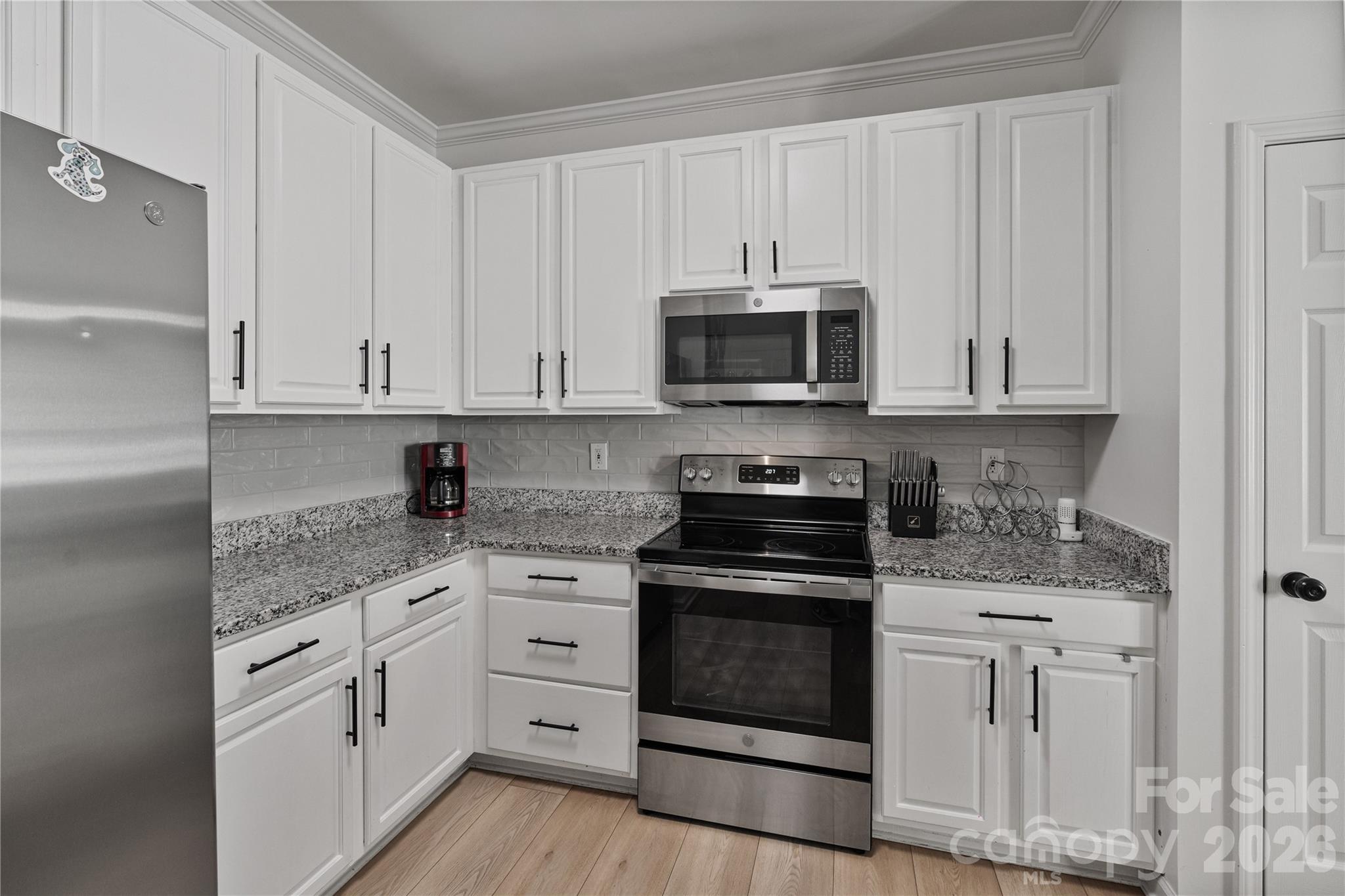 706 Shellstone Place Fort Mill, SC 29708 - Photo 12 of 23 a kitchen with white cabinets and appliances