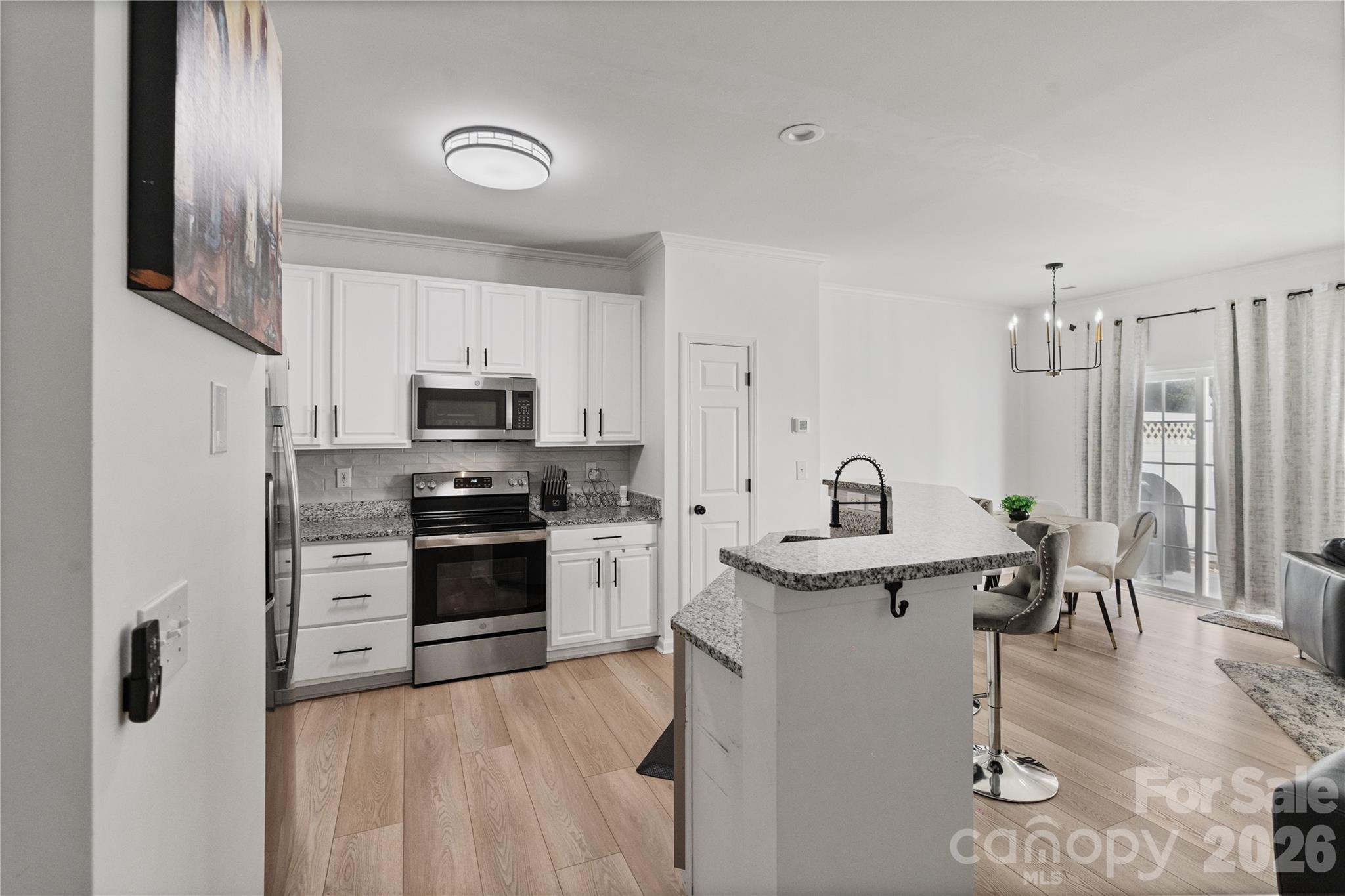 706 Shellstone Place Fort Mill, SC 29708 - Photo 9 of 23 a kitchen with stainless steel appliances granite countertop a stove top oven a sink dishwasher and a refrigerator with wooden floor