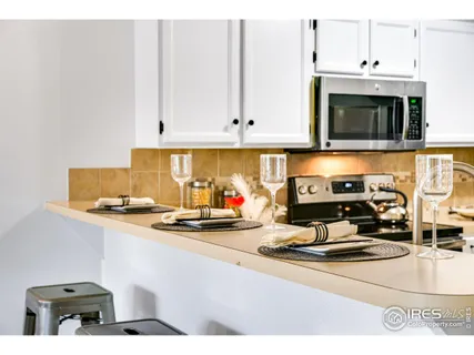 a kitchen with a stove and a white cabinets