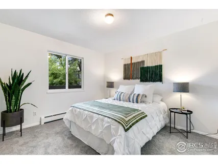 a bedroom with a large bed and a potted plant