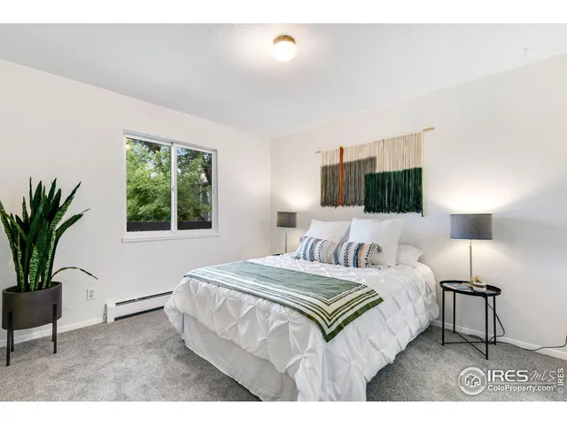 a bedroom with a large bed and a potted plant