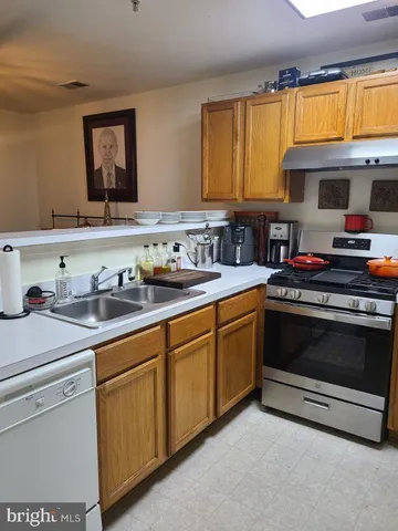 a kitchen with stainless steel appliances a stove a refrigerator and a window