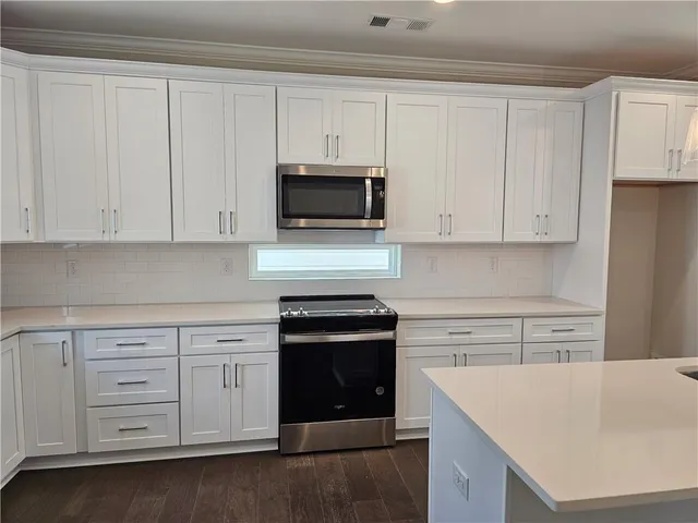 a kitchen with white cabinets and a stove