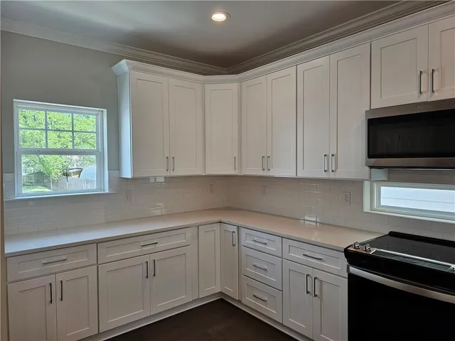 a kitchen with kitchen island a sink stainless steel appliances and cabinets