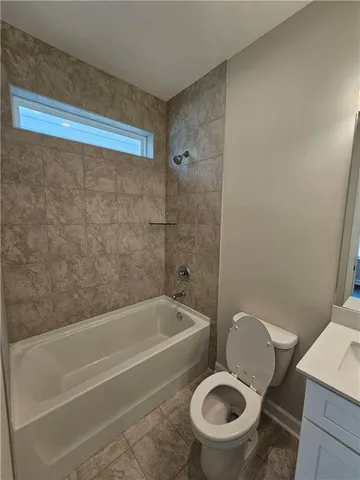 a white toilet sitting next to a bath tub and a sink