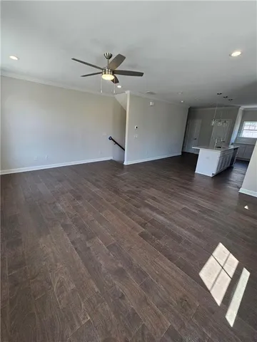 a view of kitchen with kitchen island stainless steel appliances wooden floor and living room view