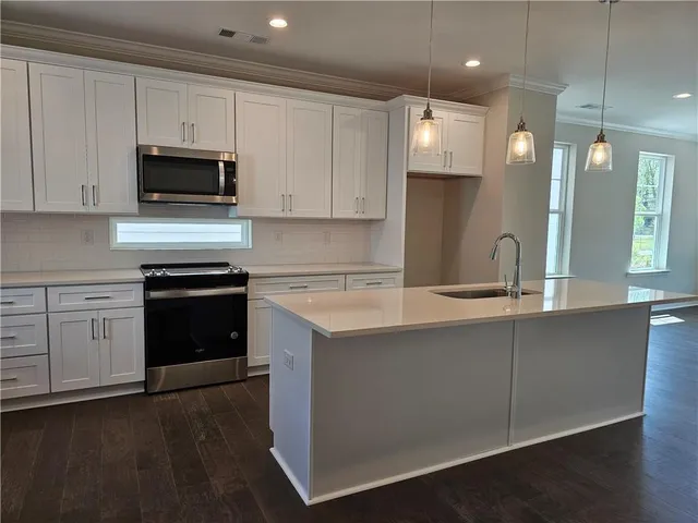 a kitchen with white cabinets and stainless steel appliances