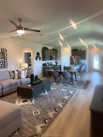 a living room with lots of furniture and view of kitchen