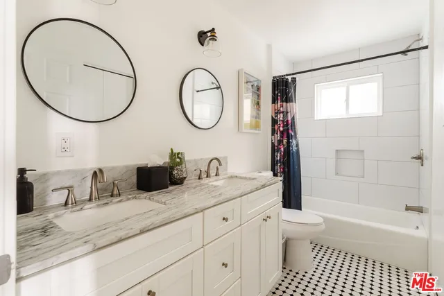 a bathroom with a granite countertop sink a toilet and a mirror
