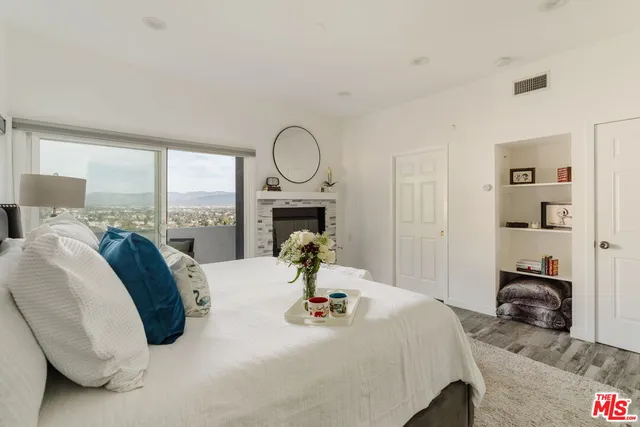 a bedroom with bed and a large window