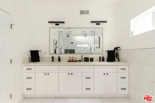 a kitchen with white cabinets and sink