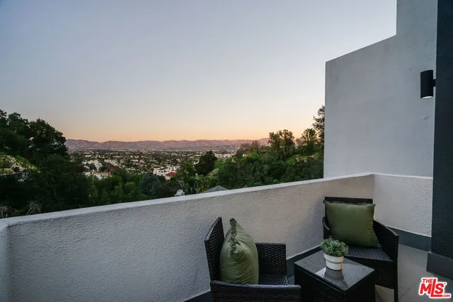 a view of a balcony with mountain view and wooden floor