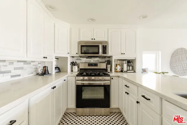 a kitchen with granite countertop a stove sink and cabinets