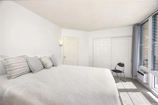 a spacious bedroom with a bed and a large window