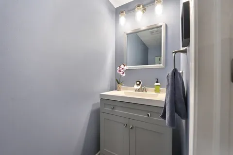 a bathroom with a granite countertop sink and a mirror