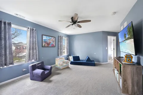 a living room with furniture flat screen tv and a large window