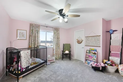 a living room with baby crib furniture and a window