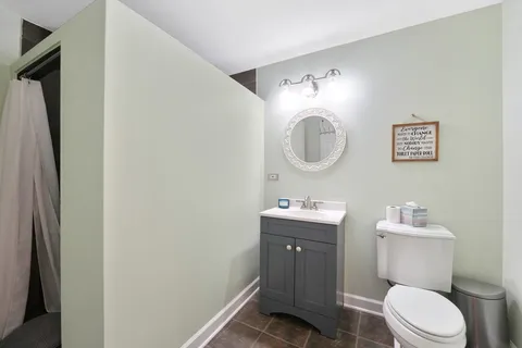 a bathroom with a toilet a sink and mirror