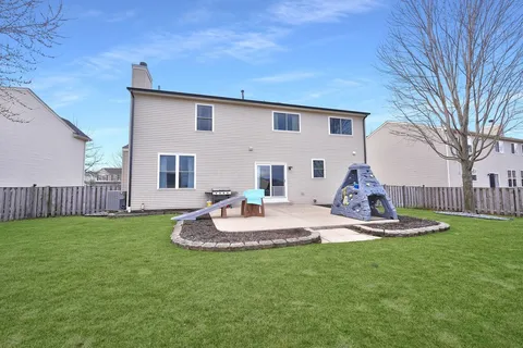 a view of a house with backyard and sitting area