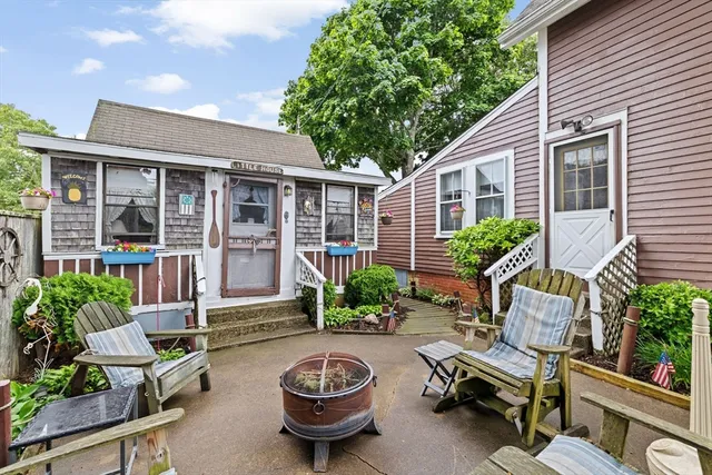 a view of a backyard with table and chairs potted plants and a fire pit