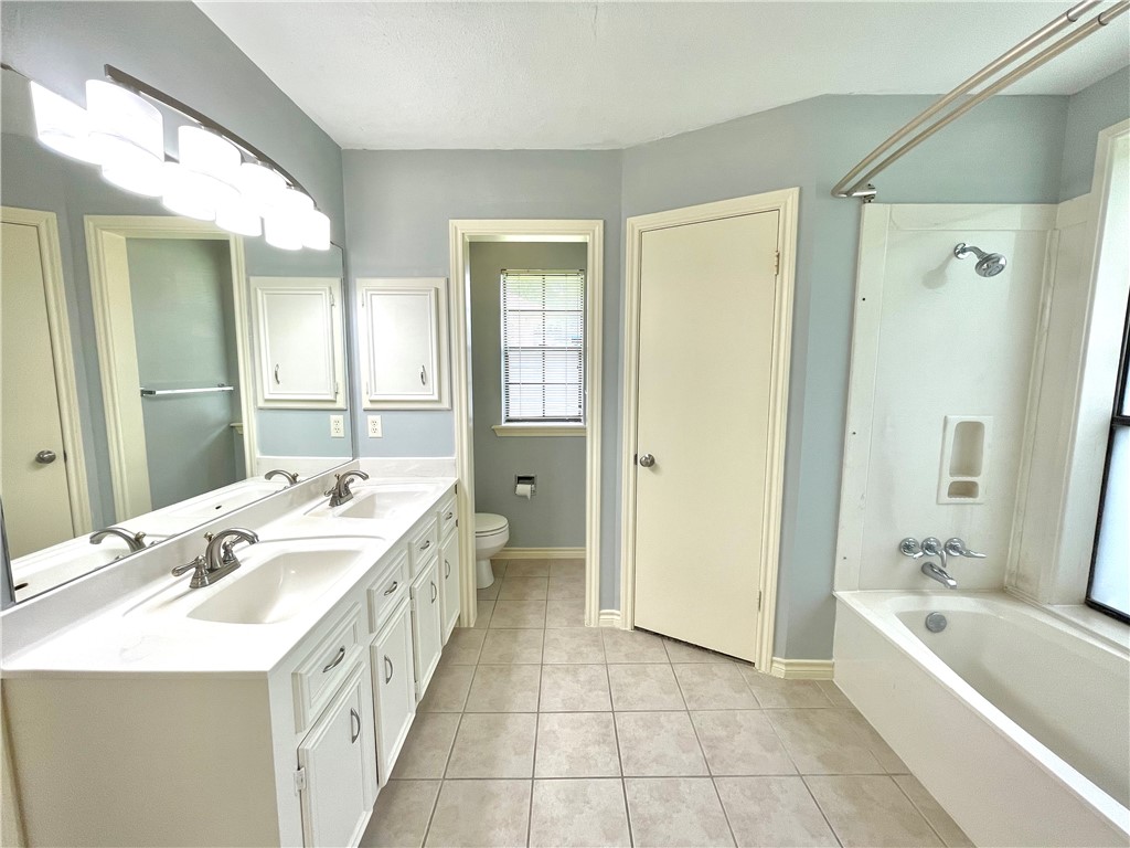 4508 Kensington Road Bryan, TX 77802 - Photo 13 of 25 Full bathroom with vanity, toilet, tub / shower combination, and tile patterned flooring