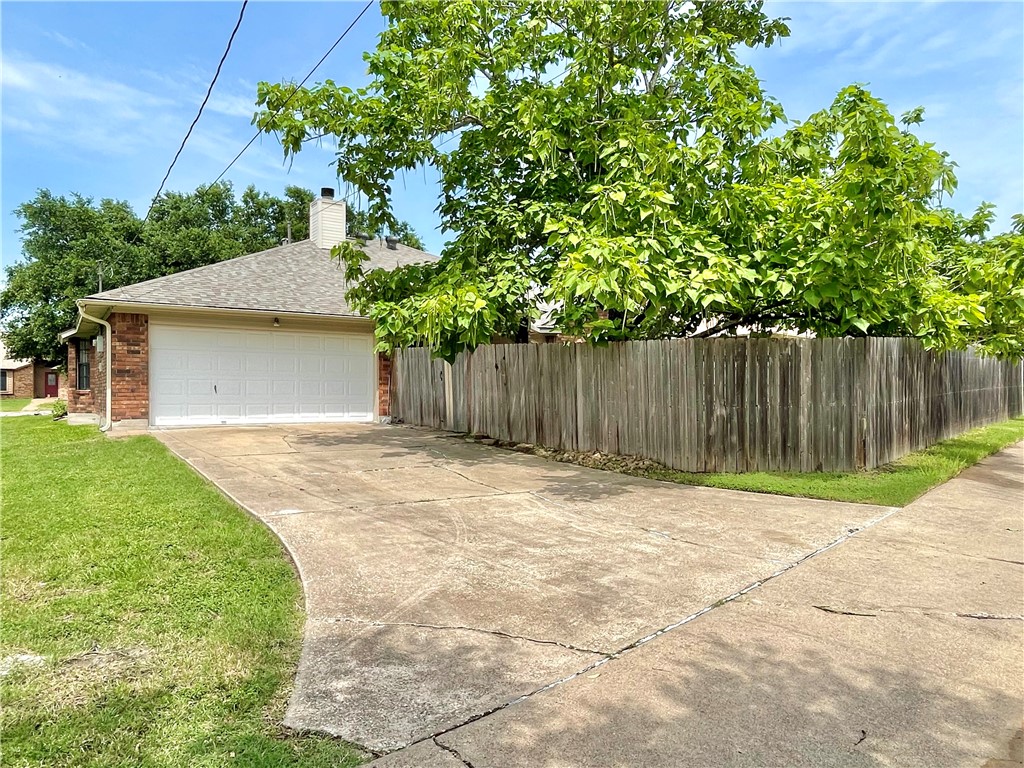 4508 Kensington Road Bryan, TX 77802 - Photo 25 of 25 View of side of property featuring a garage and a lawn