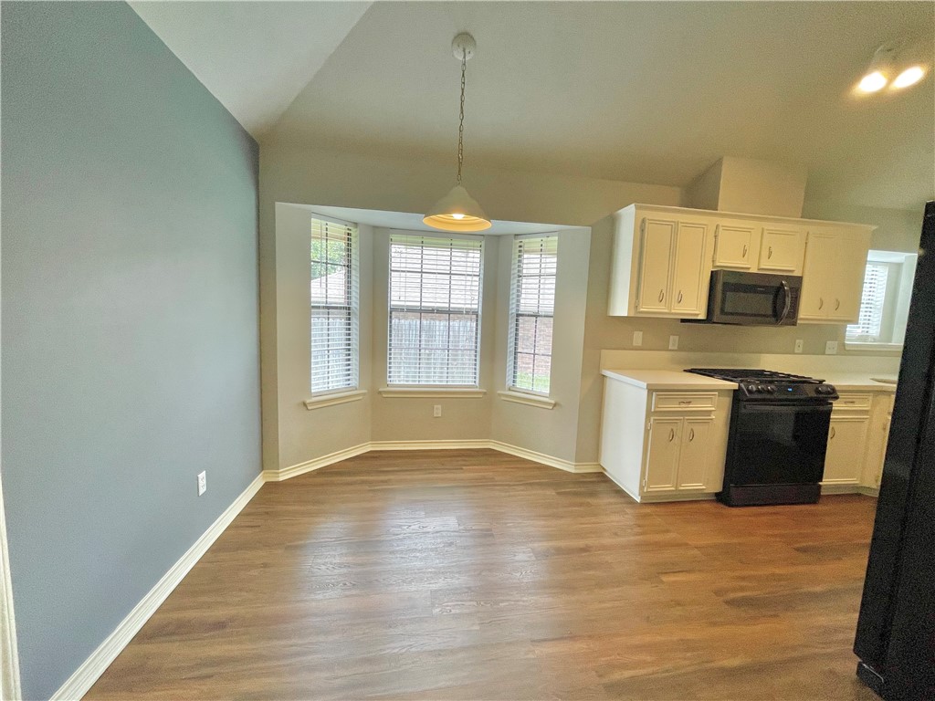 4508 Kensington Road Bryan, TX 77802 - Photo 5 of 25 Kitchen featuring lofted ceiling, white cabinetry, light wood-type flooring, pendant lighting, and gas range oven