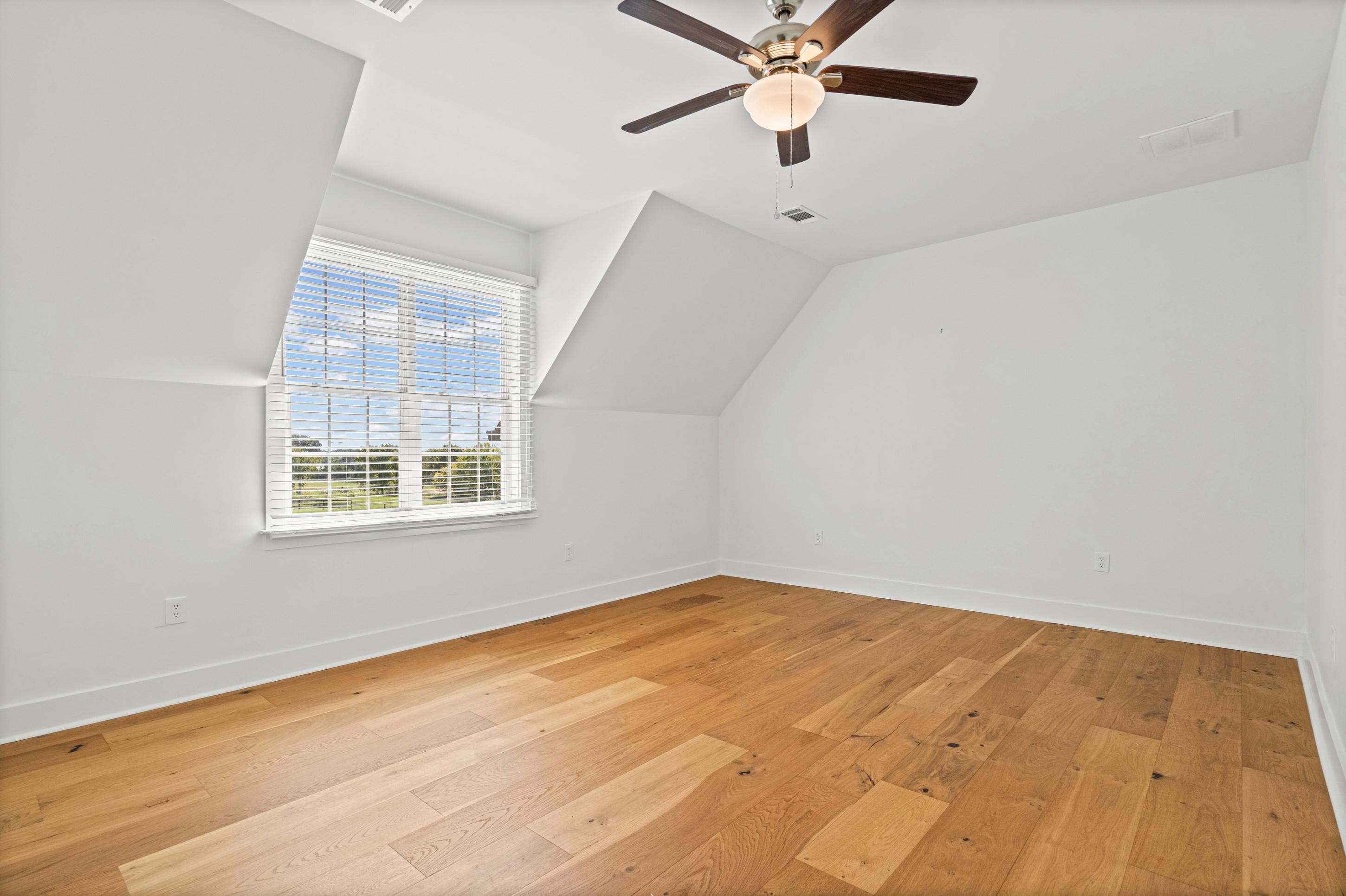 620 Diffee Road Moscow, TN 38057 - Photo 16 of 25 Angled ceiling, wood flooring, white walls, window with blinds, ceiling fan, and a walk in closet