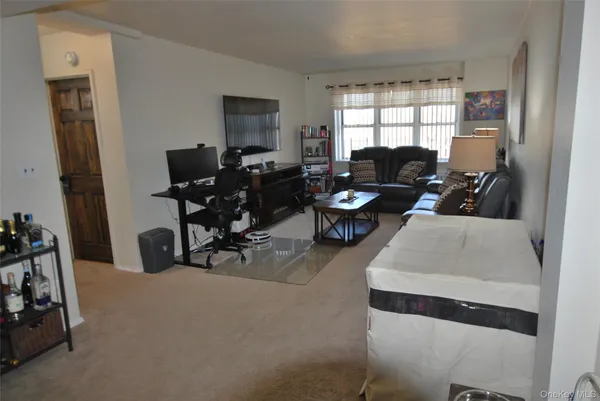 a living room with furniture a window and gym equipment