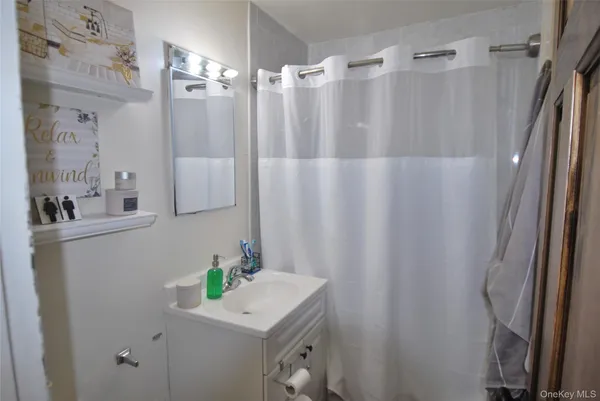 a bathroom with a sink a mirror and a shower curtain