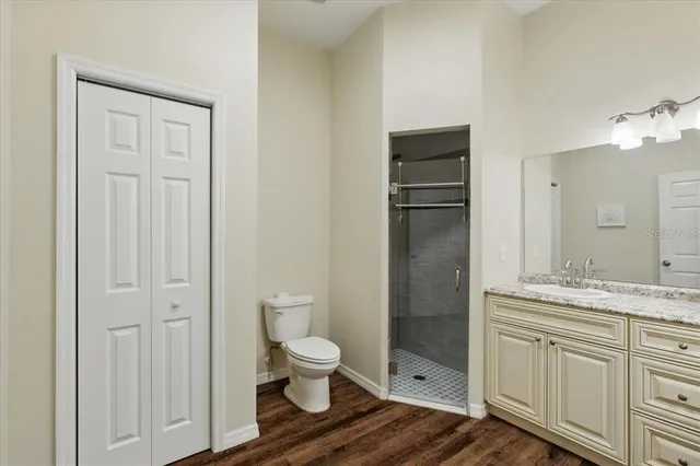 a bathroom with a granite countertop sink toilet and shower
