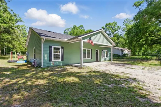a view of a house with backyard and trees