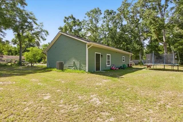 a view of a house with a backyard and a tree