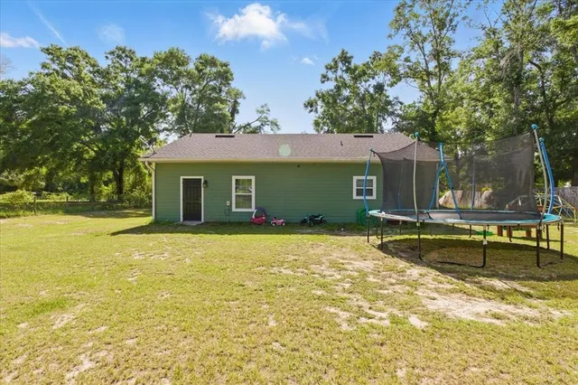 a view of a house with pool and a yard