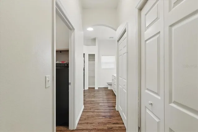 a view of a hallway with wooden floor and staircase
