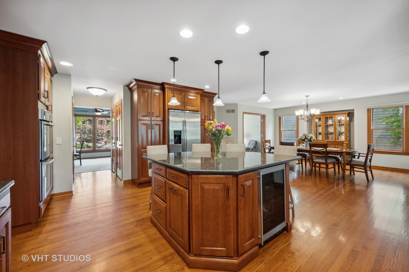 2758 Miller Road Geneva, IL 60134 - Photo 6 of 29 a kitchen with stainless steel appliances granite countertop a kitchen island a stove a refrigerator a dining table and chairs with wooden floor