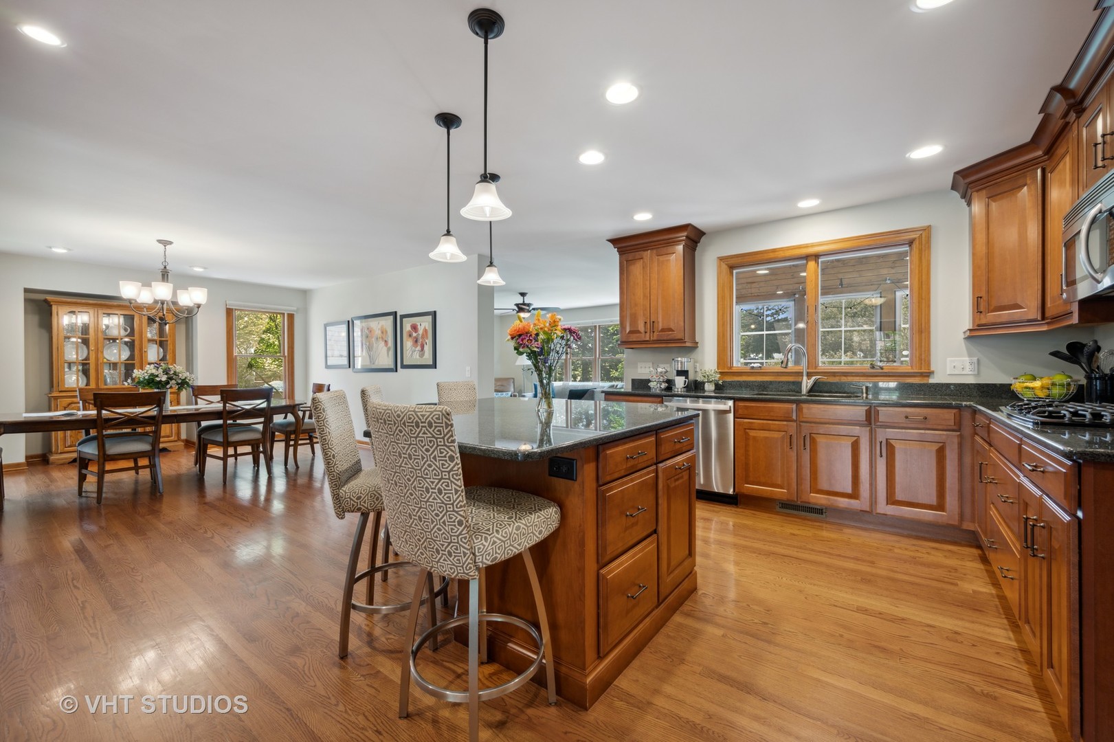 2758 Miller Road Geneva, IL 60134 - Photo 7 of 29 a kitchen with stainless steel appliances granite countertop a stove top oven a sink dishwasher a dining table and chairs with wooden floor